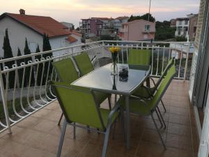 a table and chairs on a balcony with a view at Apartments Rube in Primošten