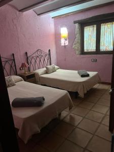 two beds in a room with pink walls and windows at Ven-Al-Azahar in Enguera +24 photos