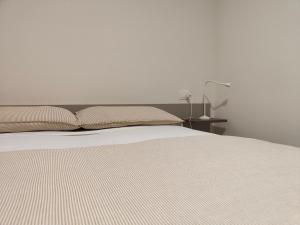 a bedroom with a white bed and a lamp at Soggiorno in villa - apt with kitchen and terrace in Gambellara