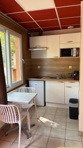 a kitchen with a table and a table and chairs at Studio au bord de la Rivière in Florentin-la-Capelle