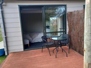 a patio with a table and chairs on a deck at Adorable studio cottage with mountain views in Staveley