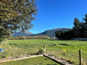 a field of crops with mountains in the background at Adorable studio cottage with mountain views in Staveley +5 photos