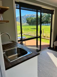 a kitchen with a sink and a view of a yard at Adorable studio cottage with mountain views in Staveley