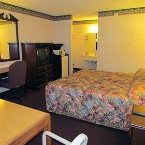 Habitación de hotel con 2 camas y escritorio en Eagle Inn Sumter, en Sumter