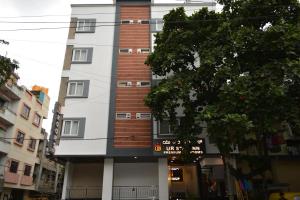 バンガロールにあるHotel Ur Stay Innの前に看板がある高い建物