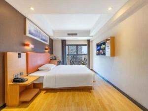 a bedroom with a large white bed and a desk at 7Days Premium Chongqing Jiangbei International Airport Rongchuang in Chongqing +202 photos