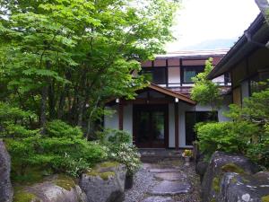 uma casa com um caminho de pedra em frente a um edifício em Pension Kinoshita em Takayama