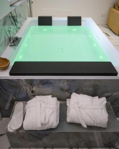 La salle de bains est pourvue d'une baignoire et de serviettes sur une étagère. dans l'établissement Suite 18, à Polignano a Mare 13 autres photos