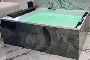 une baignoire avec un plateau en verre dans une salle de bain dans l'établissement Suite 18, à Polignano a Mare