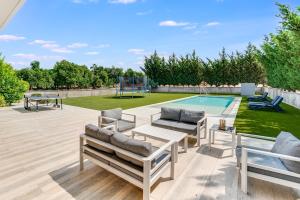 eine Terrasse mit Liegestühlen und einem Pool in der Unterkunft Goudi Residence in Goudhi