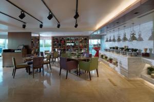 a restaurant with tables and chairs in a room at DAMAC Maison Canal Views in Dubai