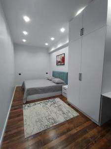 a bedroom with a bed and white cabinets and a rug at Bukhara Penthouse in Bukhara
