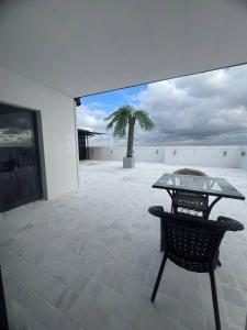 a patio with a glass table and a palm tree at Bukhara Penthouse in Bukhara