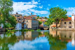 a river in a city with buildings and a bridge at Apartamento com charme no centro histórico - Escura 36 in Viseu