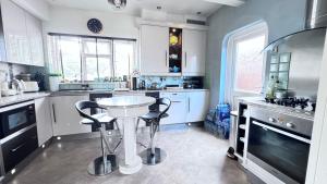 a kitchen with a table and two stools in it at The Bush Residence, Shepperton - Two Ground Floor Guest Bedrooms in Shepperton