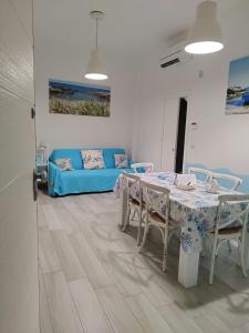 Una sala de estar con una mesa y un sofá azul. en Casa Onda Bianca, en Savelletri di Fasano