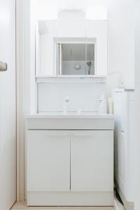 a white kitchen with a sink and a mirror at Geisha Blue Ryusenji in Kasugai
