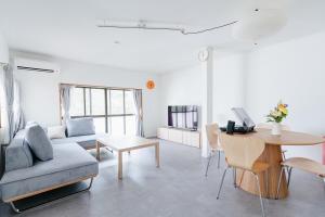 a living room with a couch and a table at Geisha Blue Ryusenji in Kasugai