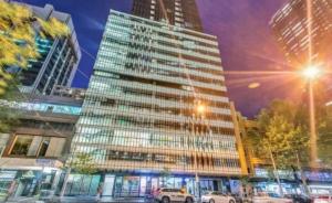 a tall building with cars parked in front of it at Melbourne's Premium on Collins in Melbourne