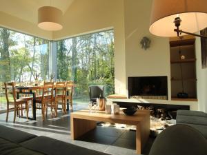 ein Wohnzimmer mit Tisch und Kamin in der Unterkunft Gite with swimming pool situated in wonderful castle grounds in Gesves in Gesves