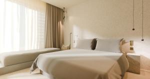 a bedroom with a large white bed and a window at Hotel Taro Santa Cruz in Santa Cruz de Tenerife