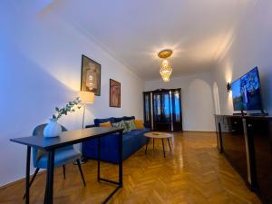 a living room with a blue couch and a table at Kyiv Milano Apartment in Kyiv