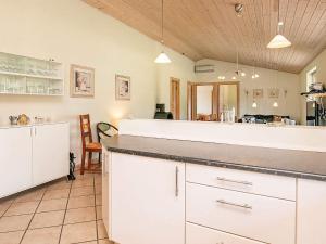 a kitchen with white cabinets and a counter top at 12 person holiday home in Hals in Hals