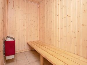 a sauna with a wooden bench and a trash can at 12 person holiday home in Hals in Hals +15 photos