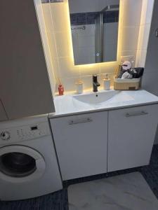 a bathroom with a sink and a washing machine at Maya Bay Luxury Apartment in Kalyves Poligirou