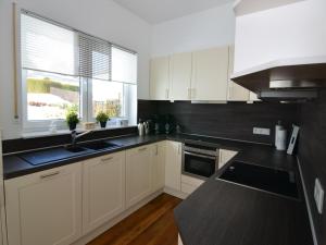a kitchen with white cabinets and a sink and a window at Moderne Villa in Medebach Küstelberg in Medebach