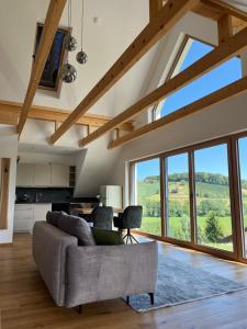 加姆利茨Weinloft Gamlitz的带沙发和大窗户的客厅