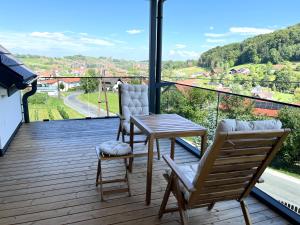 a balcony with a table and two chairs and a view at Weinloft Gamlitz in Gamlitz