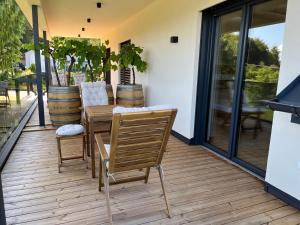 a patio with a wooden table and chairs on a deck at Weinloft Gamlitz in Gamlitz