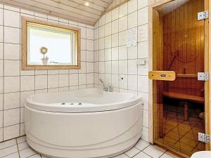 eine weiße Badewanne im Bad mit Fenster in der Unterkunft 10 person holiday home in Væggerløse in Bøtø By + 26 Fotos