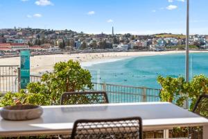 un tavolo e sedie con vista sulla spiaggia di Absolute Beachfront Luxury a Sydney Altre 16 foto