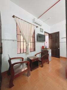 a living room with two chairs and a tv at ANH QUÂN hotel in Vung Tau