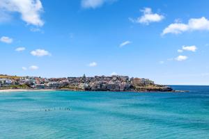 un gruppo di uccelli in acqua su una spiaggia di Absolute Beachfront Luxury a Sydney