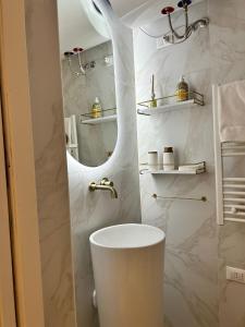 Un baño blanco con inodoro y espejo. en Alla vucciria, en Palermo