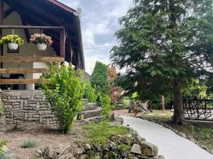 a house with a stone path next to a building at Márai vendégház in Kács +7 photos