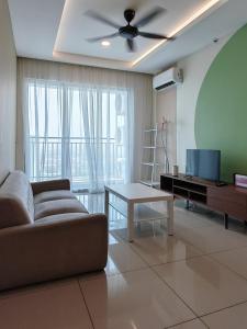 Una sala de estar con un sofá, un televisor y una mesa. en Metropol - Bukit Mertajam, en Bukit Mertajam