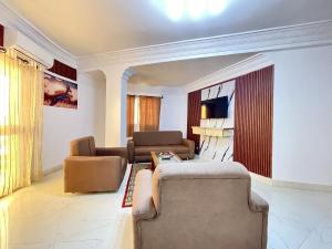 ein Wohnzimmer mit zwei Sofas und einem Fernseher in der Unterkunft Touraco Suite Hôtel Business in M'bour
