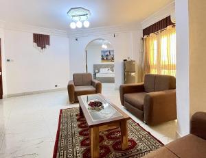 ein Wohnzimmer mit zwei Stühlen und einem Tisch in der Unterkunft Touraco Suite Hôtel Business in M'bour