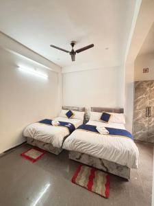 2 camas en un dormitorio con ventilador de techo en Chandrakala Residency Paying Guest House Near Kashi Vishwanath Temple and Ganga Ghats, en Varanasi