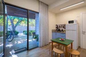 a kitchen with a refrigerator and a table with chairs at Kibbutz Kfar Masaryk Country Lodging in Kefar-Massariq