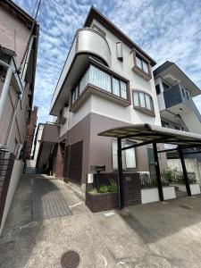 a large building with a large umbrella in front of it at T'S House Numazu in Numazu +51 photos