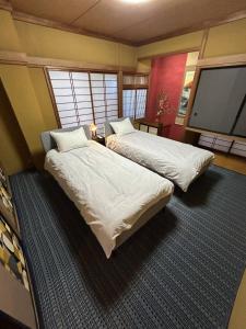 a room with two beds and a flat screen tv at T'S House Numazu in Numazu