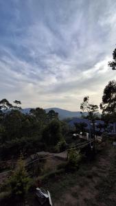 a view of a hill with trees and a sky at restogreen diva in Suryanelli