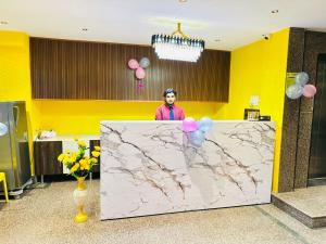 a man standing behind a marble counter with balloons at Hotel SM Comforts BTM Layout in Bangalore