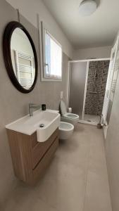 a bathroom with a sink and a toilet and a mirror at Brianza Verde 25 in Bernareggio +8 photos