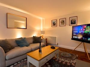a living room with a couch and a flat screen tv at Stylish 3-Bed in Historic Caerleon-GardenParking Pass The Keys in Newport